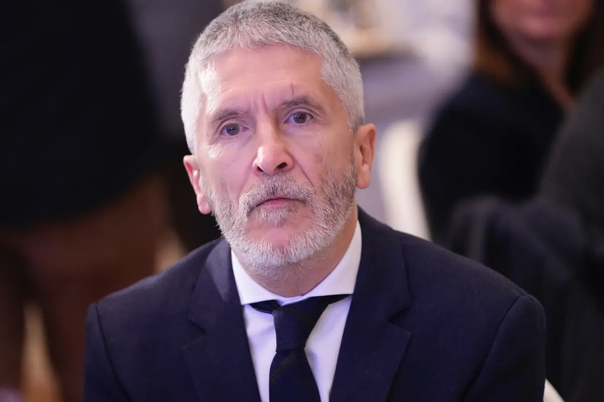 Hombre de cabello canoso y barba con expresión seria vestido con traje oscuro y corbata en un entorno interior desenfocado Hombre de cabello canoso y barba con expresión seria vestido con traje oscuro y corbata en un entorno interior desenfocado