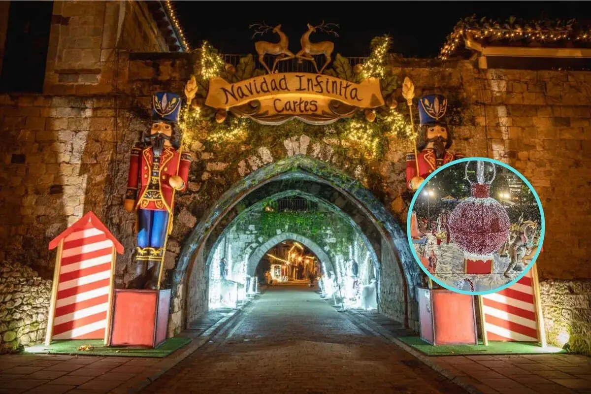 Entrada de piedra decorada con luces y figuras navideñas de soldados de cascanueces con un letrero que dice Navidad Infinita Cartes y un adorno navideño iluminado en un círculo destacado