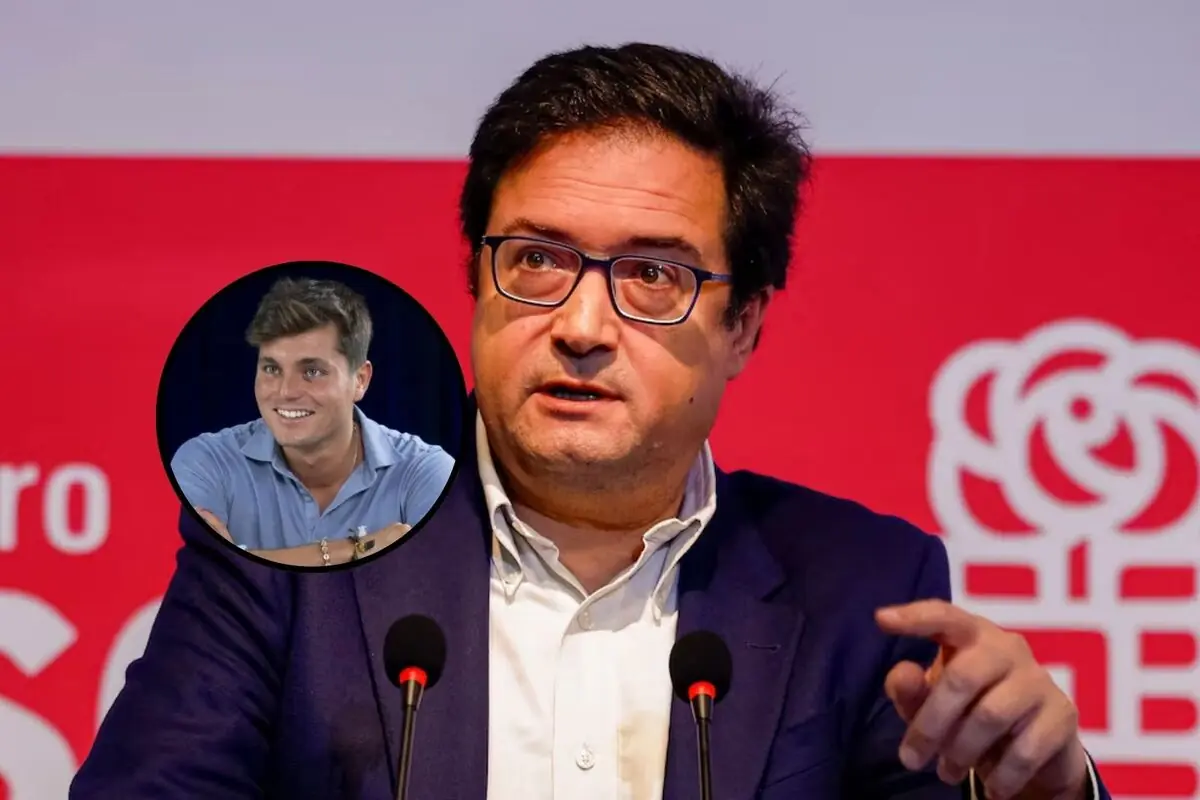 Hombre con gafas y saco azul hablando frente a micrófonos con fondo rojo y un círculo que muestra a otro hombre joven sonriendo con camisa azul claro.