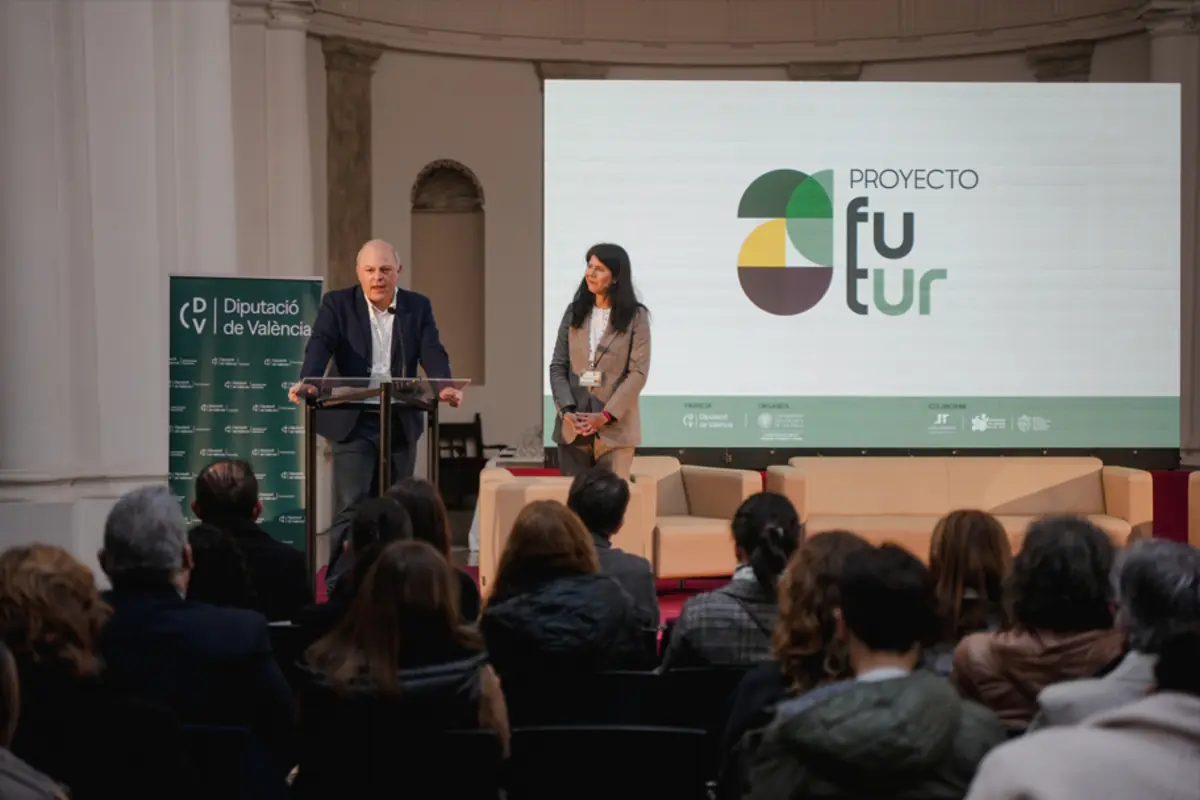 Hombre y mujer presentan el Proyecto Futur ante un público en un auditorio con pantalla gigante y cartel de la Diputación de Valencia