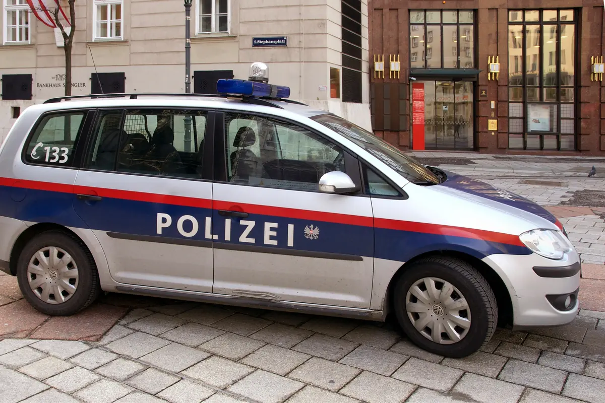 Coche patrulla de la policía austríaca estacionado en una calle urbana adoquinada