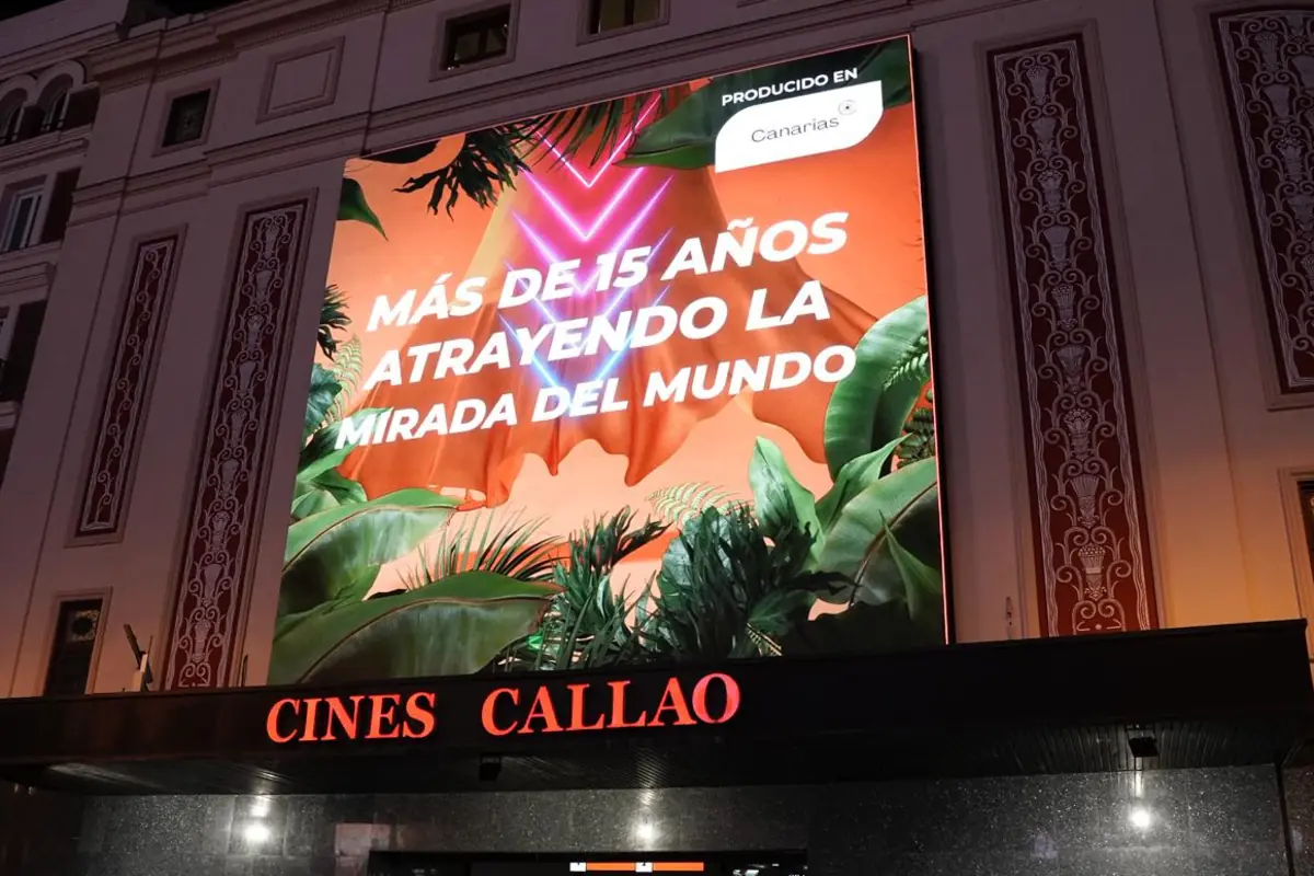 Cartel luminoso en la fachada de Cines Callao con un mensaje promocional rodeado de plantas y luces de neón Cartel luminoso en la fachada de Cines Callao con un mensaje promocional rodeado de plantas y luces de neón