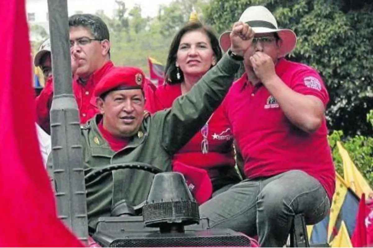 Grupo de personas con ropa roja en un vehículo durante una manifestación política al aire libre
