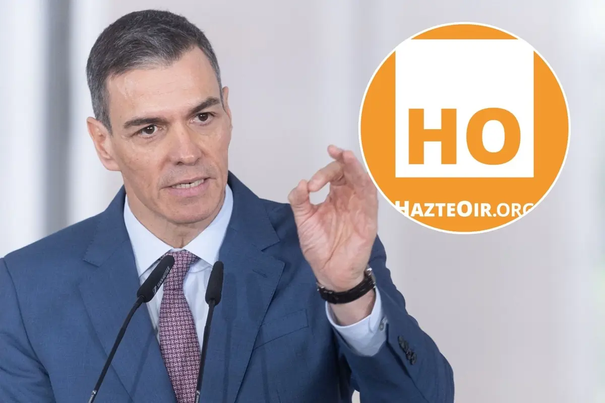 Hombre con traje azul hablando ante micrófonos y gesticulando con la mano junto al logotipo naranja de HazteOir.org
