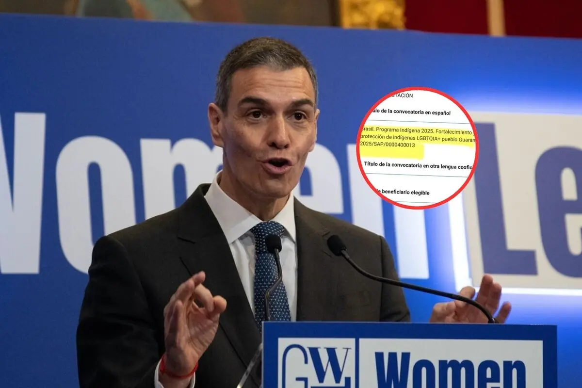 Hombre con traje hablando en un atril con micrófonos frente a un cartel azul de Women Leaders y un círculo rojo que resalta un documento ampliado en la esquina derecha de la imagen