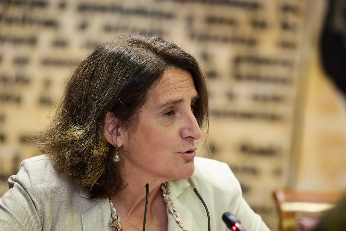 Mujer de mediana edad hablando en una conferencia con micrófono y fondo desenfocado