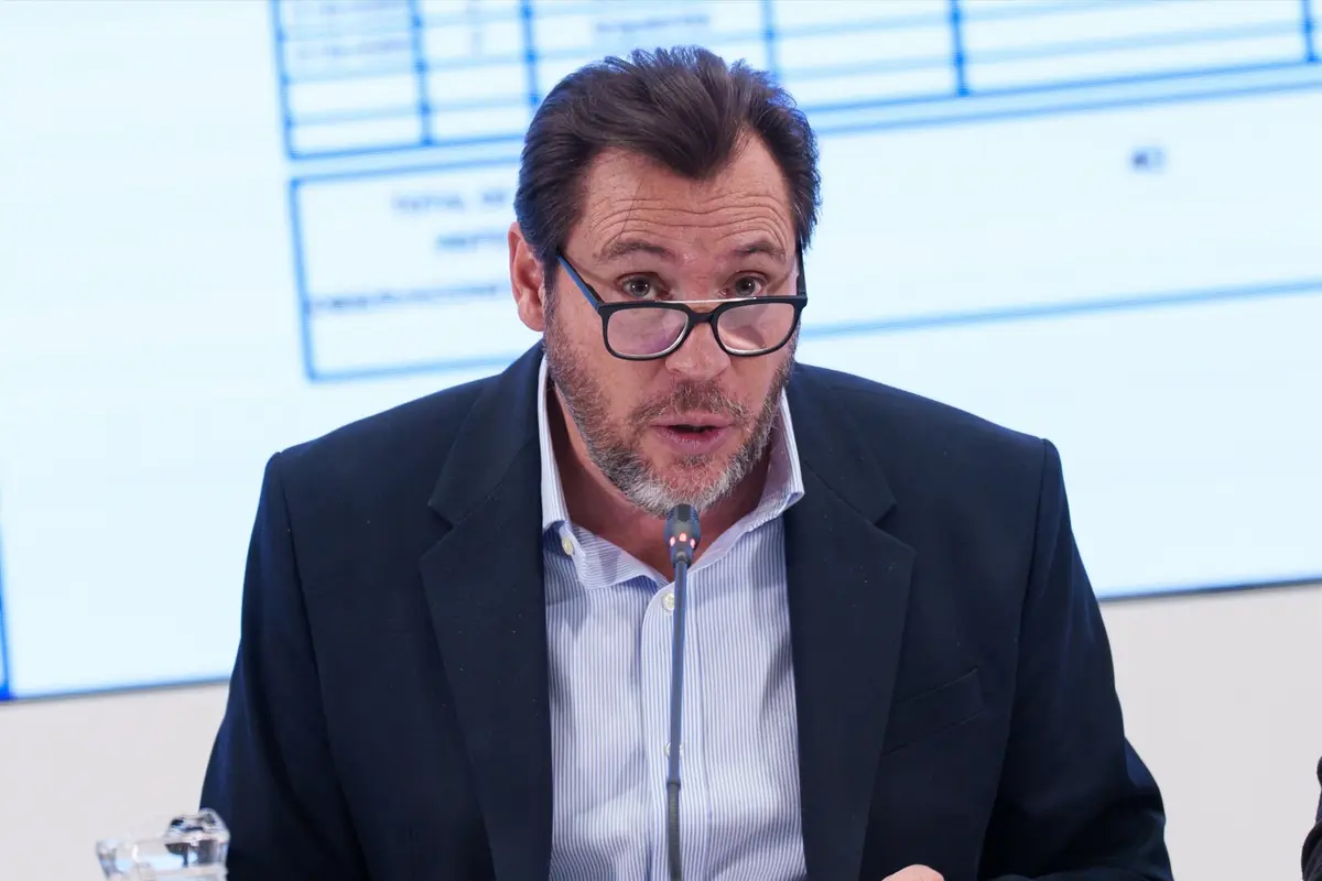 Hombre de mediana edad con gafas y barba hablando frente a un micrófono en una conferencia o reunión profesional Hombre de mediana edad con gafas y barba hablando frente a un micrófono en una conferencia o reunión profesional