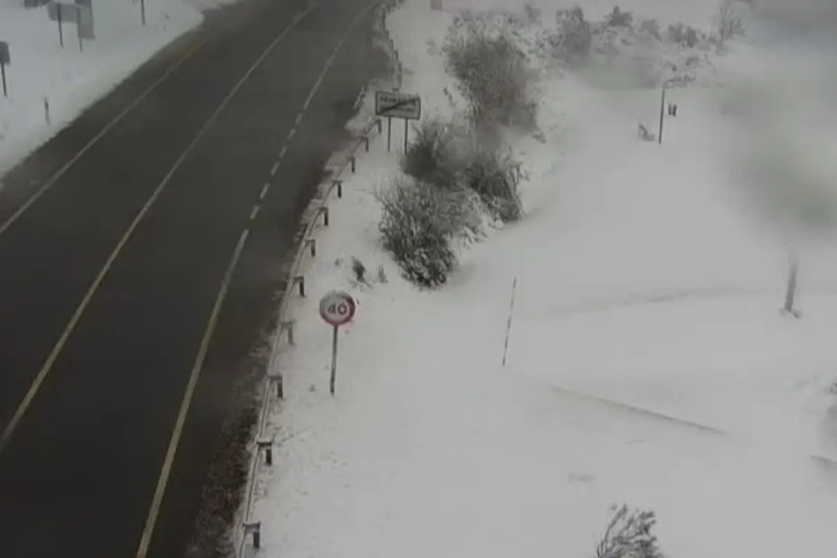 Carretera nevada con señal de límite de velocidad de 40 km h y paisaje cubierto de nieve a los lados Carretera nevada con señal de límite de velocidad de 40 km h y paisaje cubierto de nieve a los lados