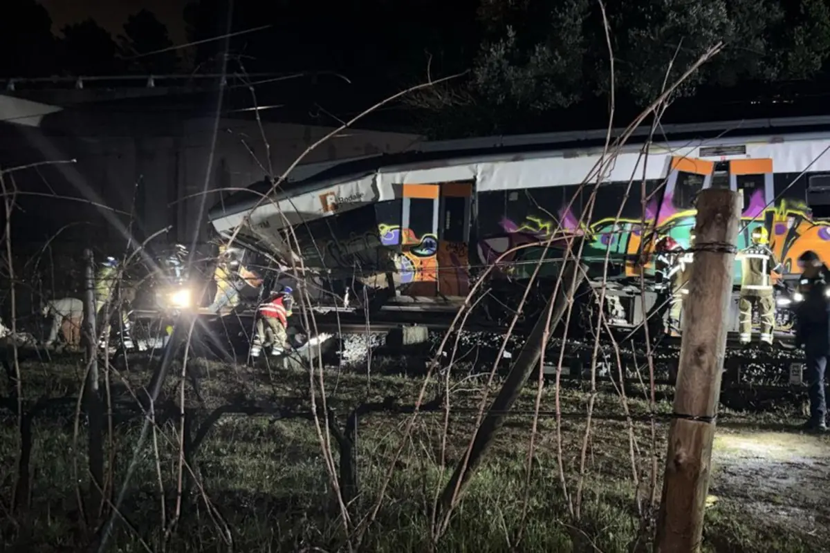 Bomberos y equipos de rescate trabajan de noche junto a un tren descarrilado con grafitis en los vagones en una zona rural rodeada de vegetación Bomberos y equipos de rescate trabajan de noche junto a un tren descarrilado con grafitis en los vagones en una zona rural rodeada de vegetación