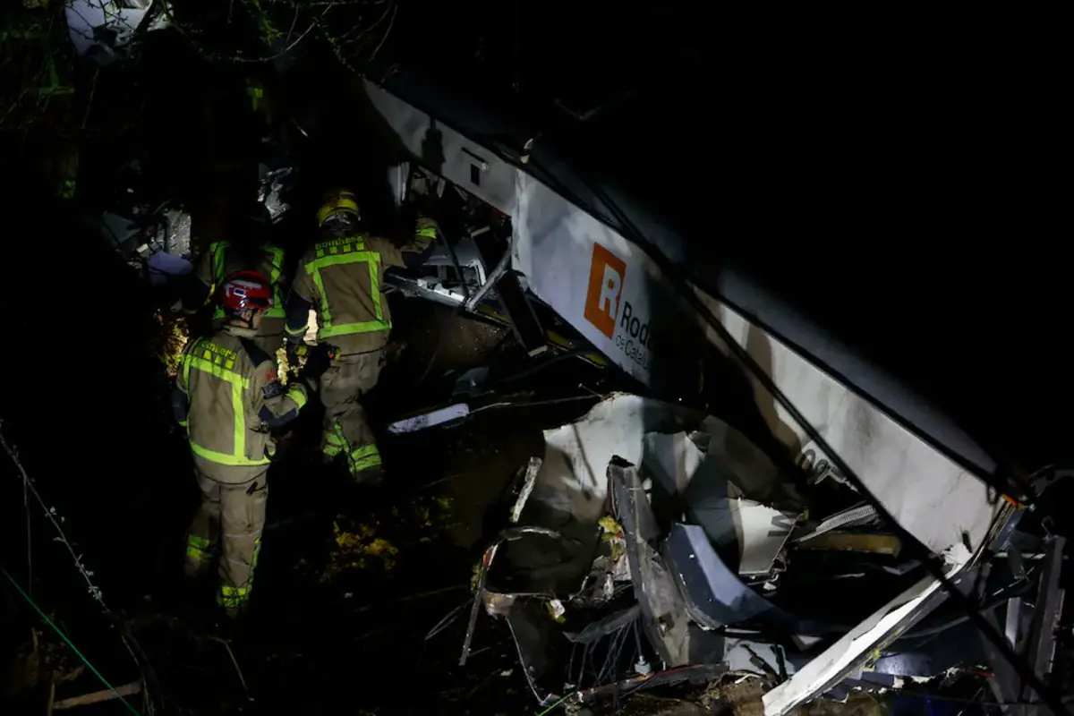 Bomberos trabajan de noche entre los restos destrozados de un autobús accidentado