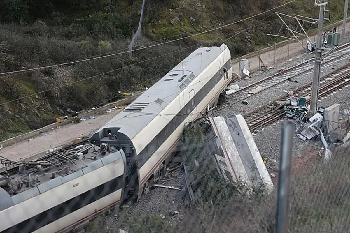 Tren de alta velocidad descarrilado con varios vagones volcados junto a la vía y restos esparcidos en una zona rural