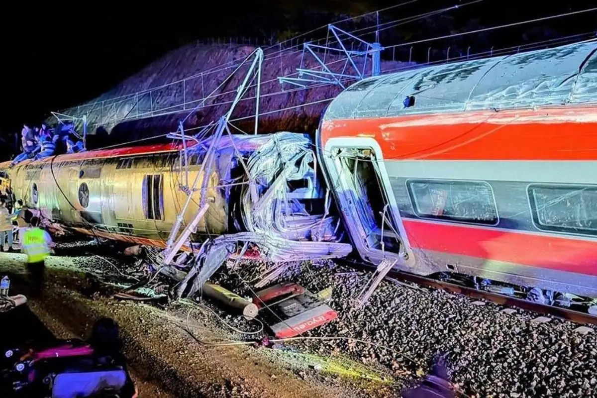 Choque nocturno de trenes con vagones descarrilados y gravemente dañados mientras equipos de emergencia trabajan en la zona