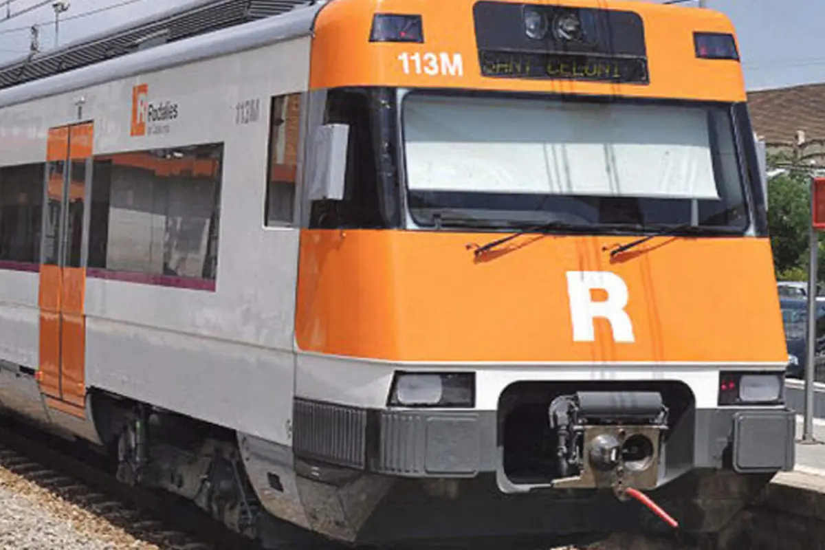Tren de cercanías de Renfe Rodalies con frontal naranja y blanco detenido en la estación