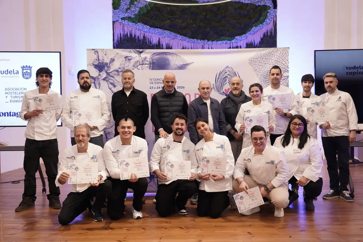 Grupo de cocineros y organizadores posando en un salón de eventos mientras muestran diplomas de finalistas de un concurso gastronómico Grupo de cocineros y organizadores posando en un salón de eventos mientras muestran diplomas de finalistas de un concurso gastronómico
