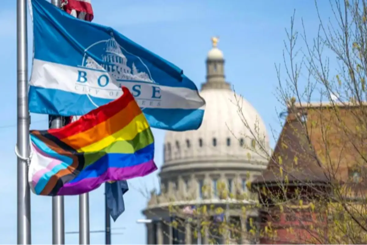Banderas de la ciudad de Boise y del orgullo LGBTQ+ ondeando frente a un edificio gubernamental con cúpula Banderas de la ciudad de Boise y del orgullo LGBTQ+ ondeando frente a un edificio gubernamental con cúpula