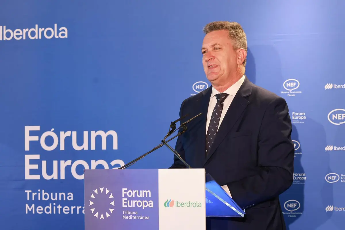 Hombre con traje oscuro hablando en un atril durante un acto del Fórum Europa Tribuna Mediterránea con logotipos de Iberdrola y NEF sobre un fondo azul