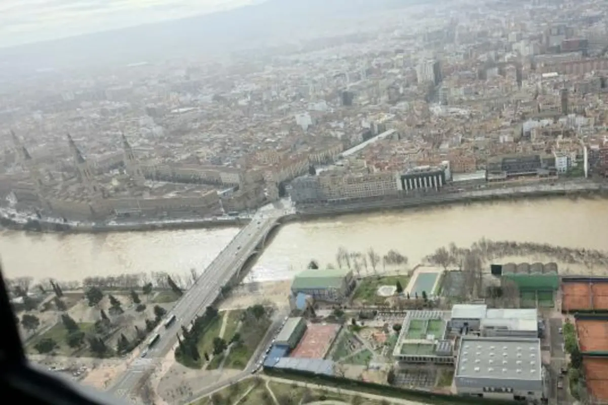 Vista aérea de una ciudad con un río caudaloso en el centro un puente que lo cruza y zonas urbanas y deportivas a ambos lados Vista aérea de una ciudad con un río caudaloso en el centro un puente que lo cruza y zonas urbanas y deportivas a ambos lados