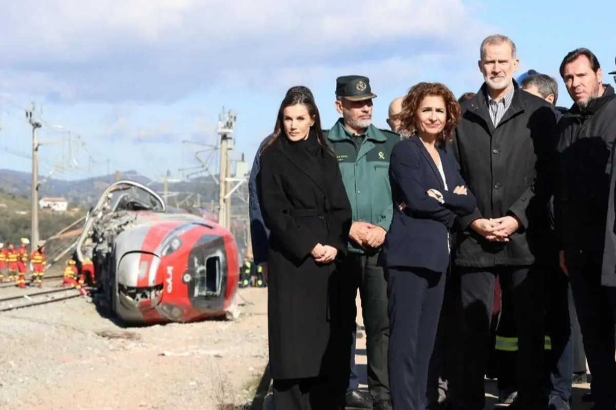 Autoridades y equipos de emergencia observan un tren volcado y gravemente dañado en una vía férrea tras un accidente