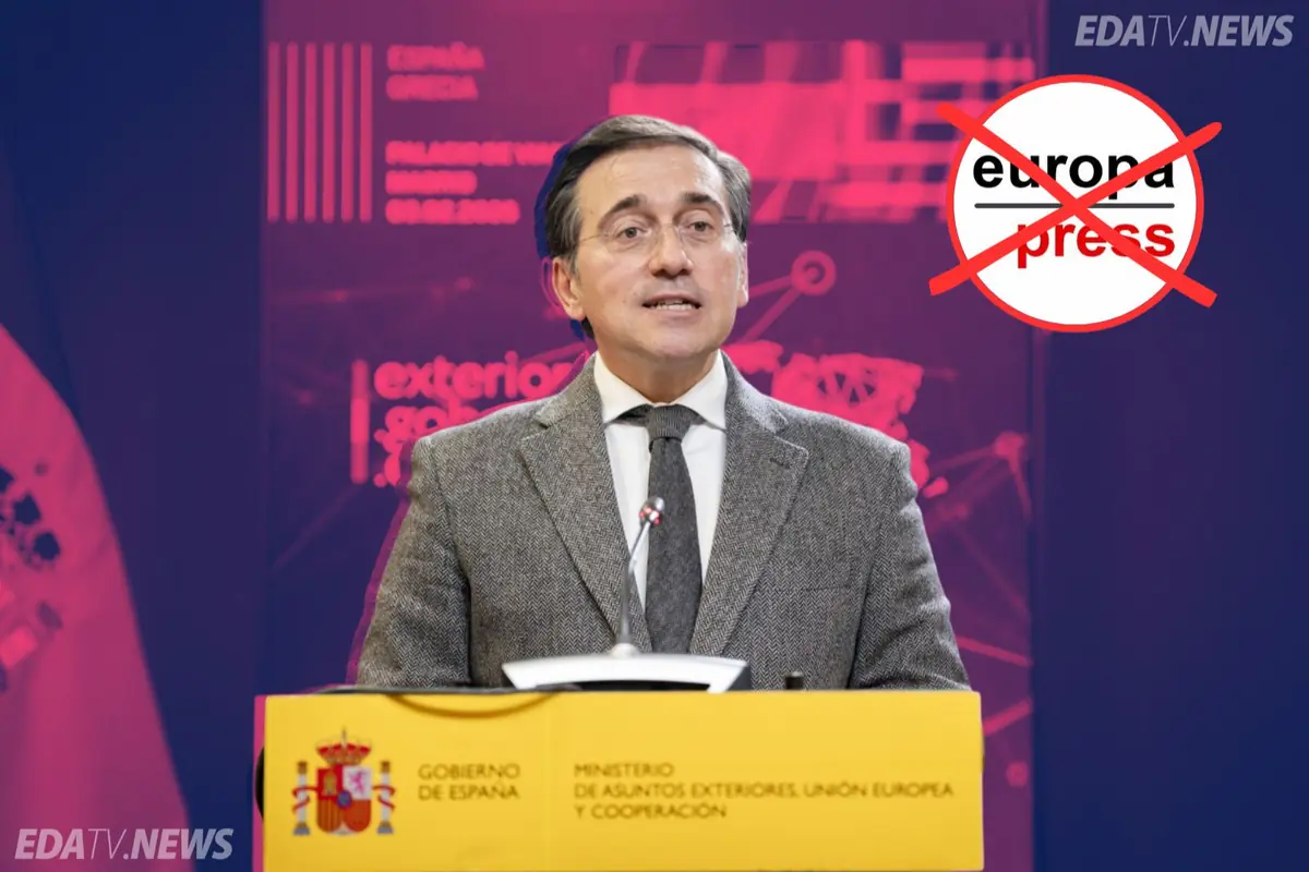 Ministro español dando una rueda de prensa en un atril del Gobierno de España con fondo morado y un logotipo de Europa Press tachado en rojo en la esquina superior derecha