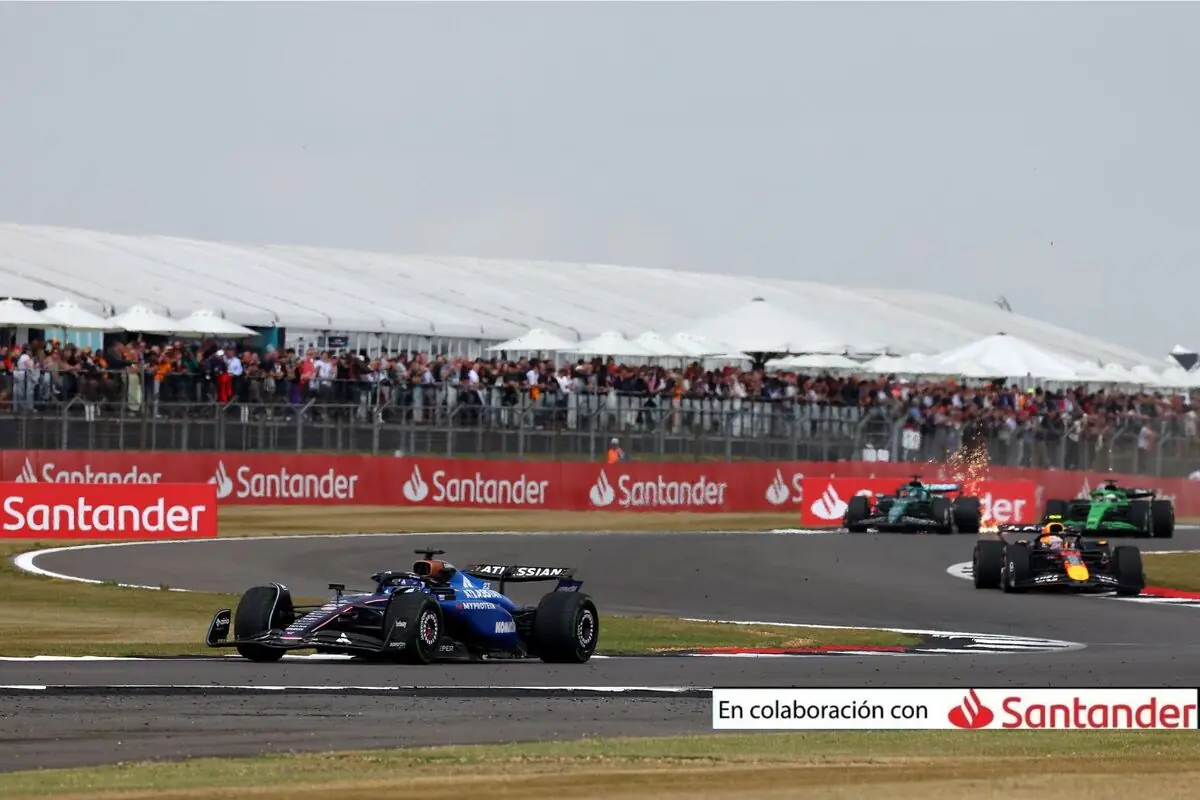 Monoplazas de Fórmula 1 compitiendo en un circuito con público en las gradas y publicidad de Santander en las vallas