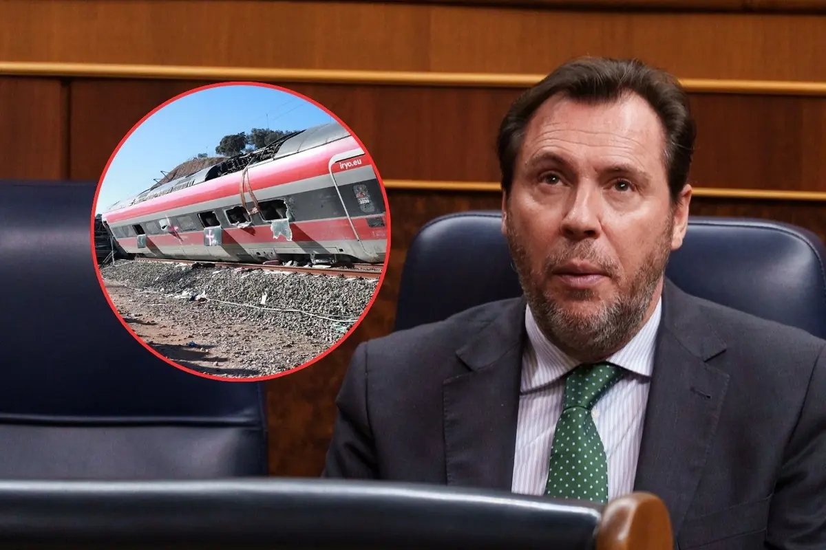 Hombre con traje y corbata verde sentado en un escaño parlamentario junto a un recuadro circular que muestra un tren averiado y descarrilado sobre las vías