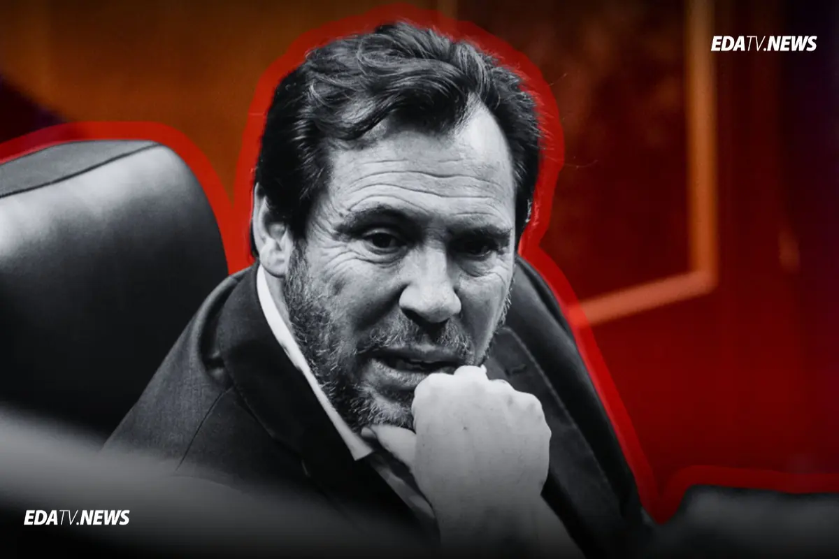 Primer plano en blanco y negro de un hombre de mediana edad con barba apoyando el mentón en su mano sentado en una butaca con fondo rojo y logotipo de EDATV NEWS en las esquinas