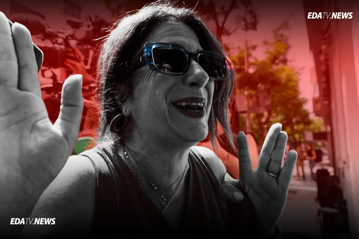 Mujer con gafas de sol sonriendo y gesticulando con las manos en una calle con fondo rojo y logotipo de EDATV NEWS