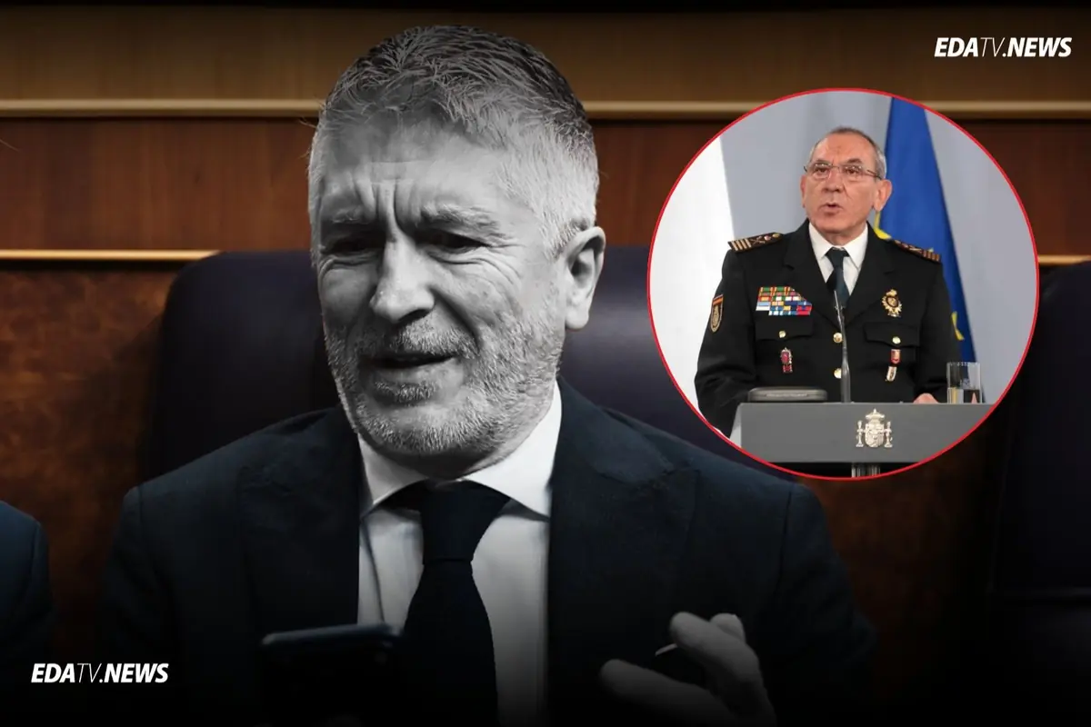 Hombre de traje sentado mirando su móvil en blanco y negro con un recuadro circular en color que muestra a un mando policial uniformado hablando en un atril con banderas de fondo