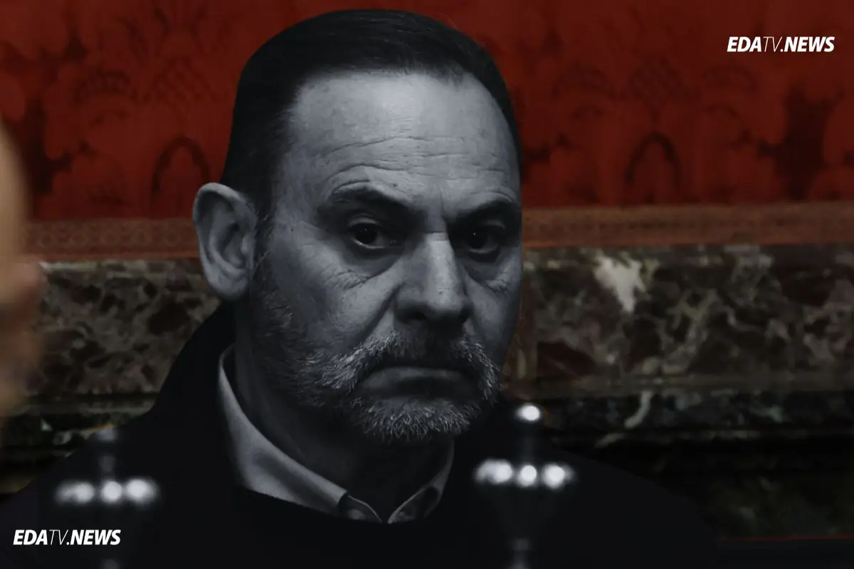 Primer plano de un hombre de mediana edad con gesto serio en un entorno interior de tonos oscuros y fondo rojo