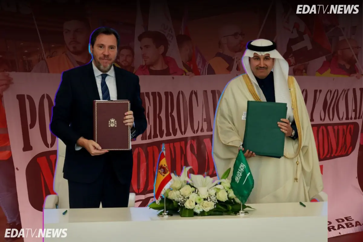 Dos representantes de España y Arabia Saudí posan con carpetas oficiales tras firmar un acuerdo frente a una mesa con flores y banderas de ambos países