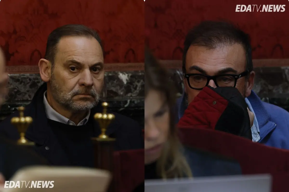 Dos hombres serios sentados en una sala con paredes rojas y detalles de mármol mientras observan algo fuera de cámara