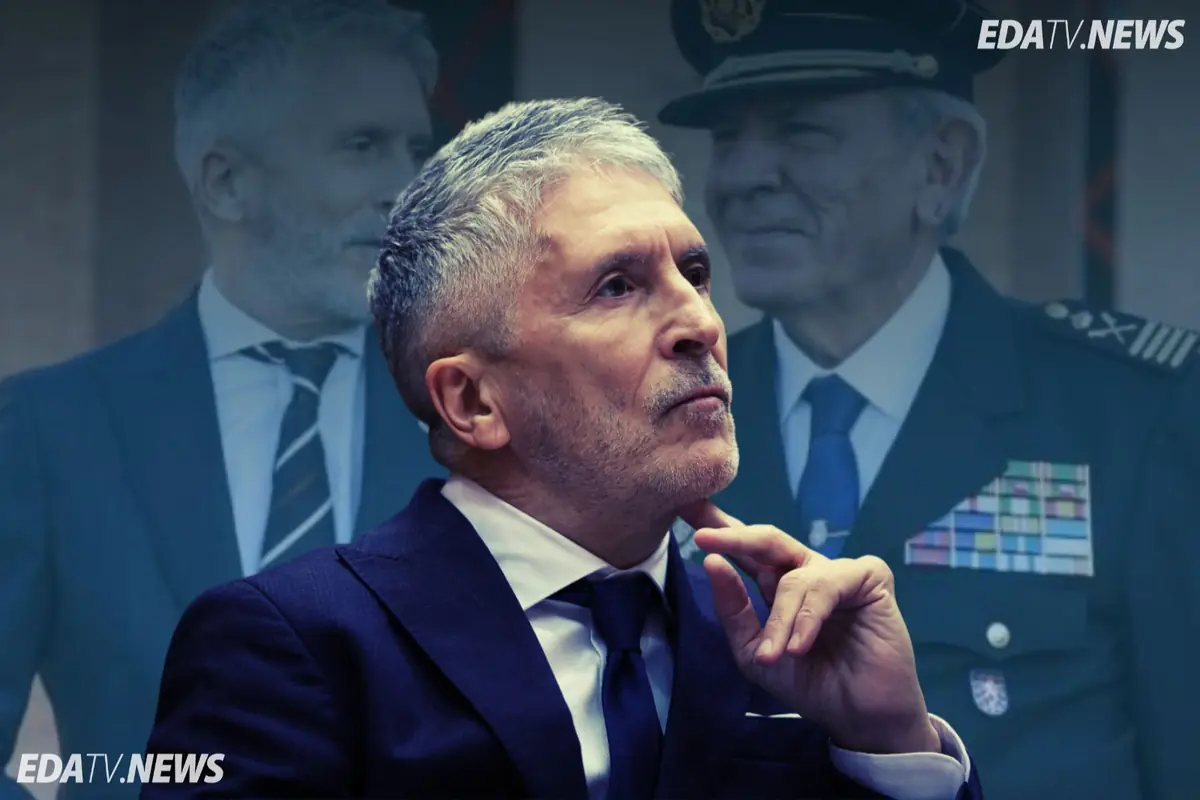 Hombre de cabello canoso con traje azul en primer plano pensativo con dos figuras uniformadas desenfocadas al fondo y logotipo EDATV NEWS en las esquinas