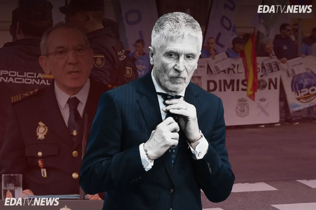 Hombre de traje ajustándose la corbata en primer plano con policías y pancartas de protesta al fondo y logotipo de EDATV NEWS en la esquina