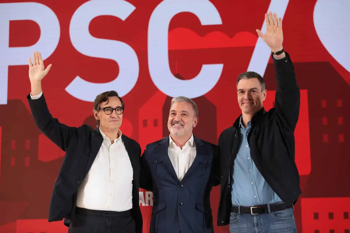 Tres hombres de pie frente a un fondo rojo con las siglas PSC dos de ellos levantan la mano en gesto de saludo