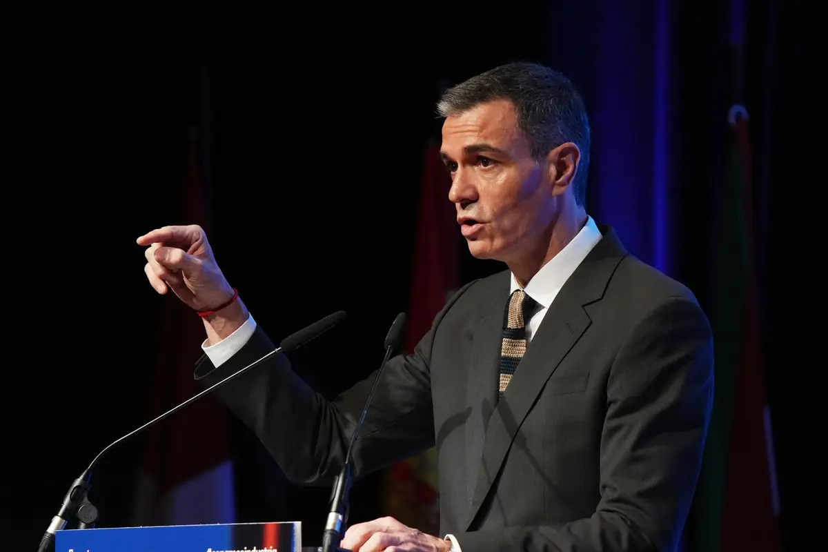 Hombre con traje oscuro hablando en un atril y gesticulando con la mano durante un discurso público