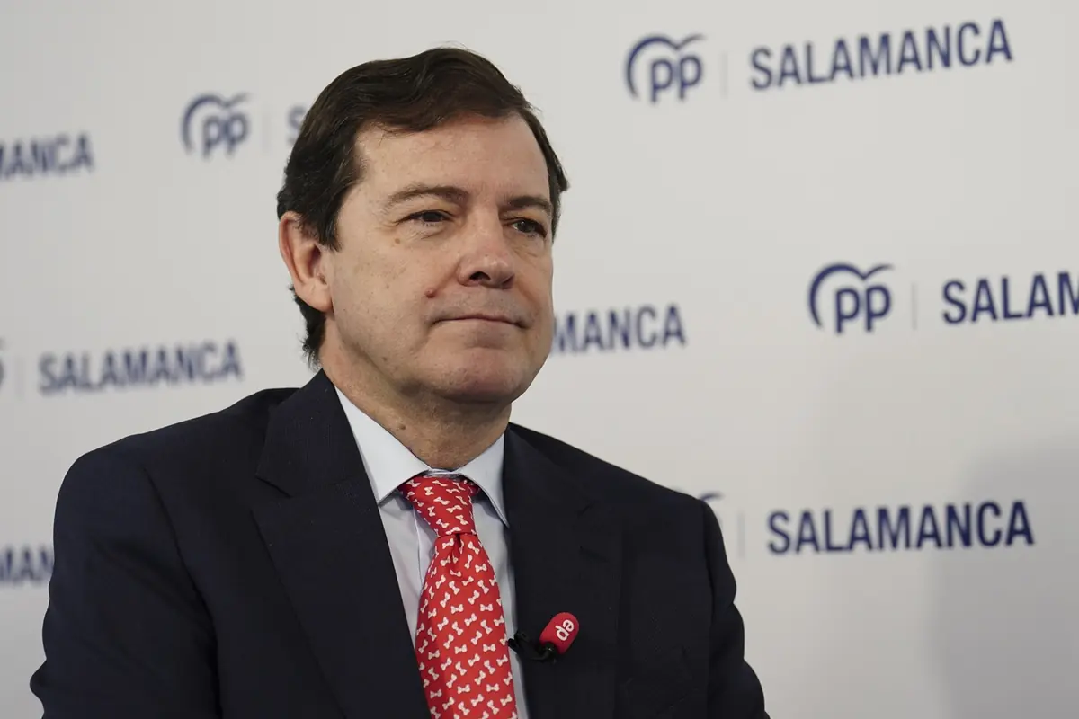 Hombre con traje oscuro y corbata roja posando frente a un fondo con el logotipo del PP y la palabra Salamanca