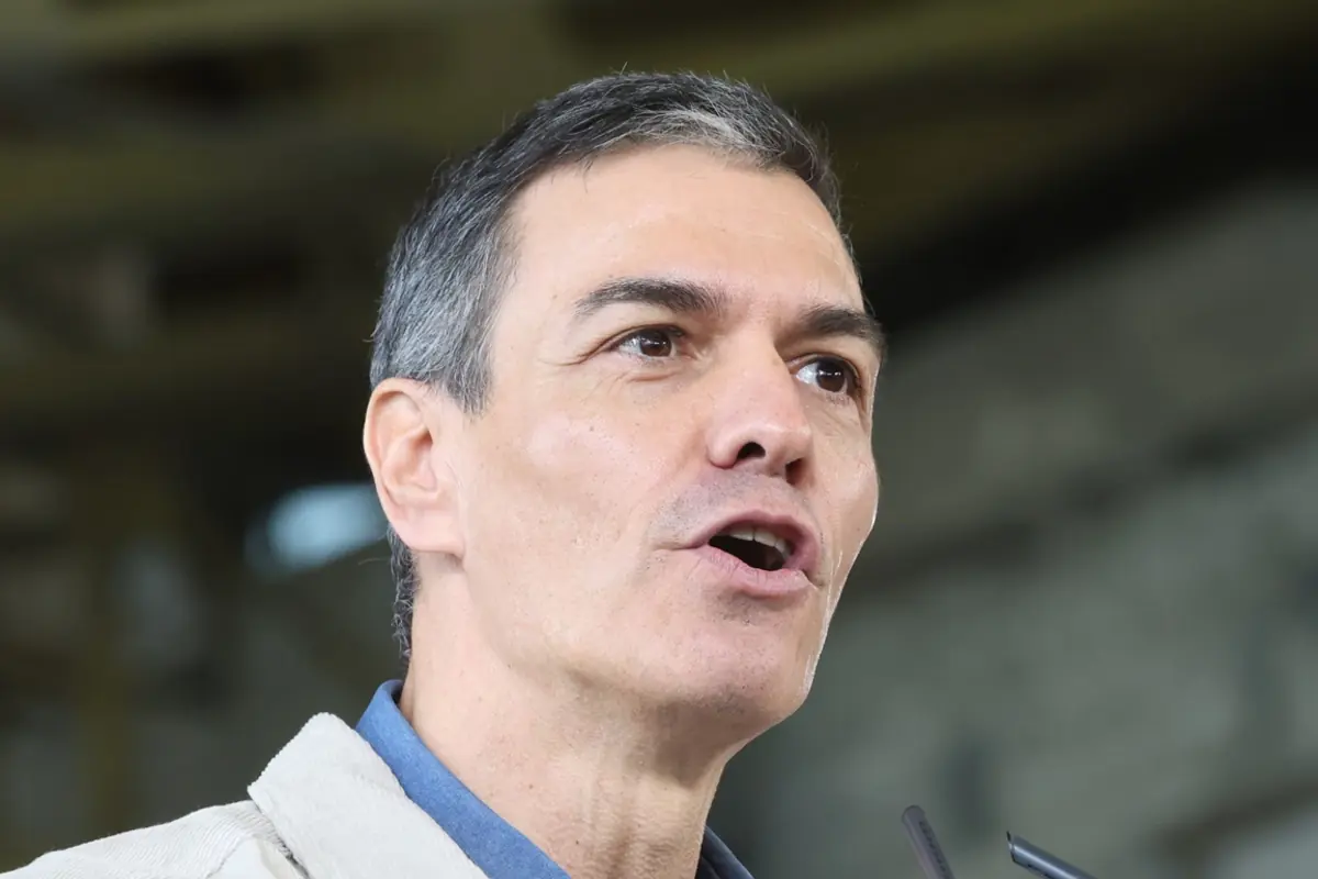 Primer plano de un hombre de mediana edad hablando frente a un micrófono en un espacio interior