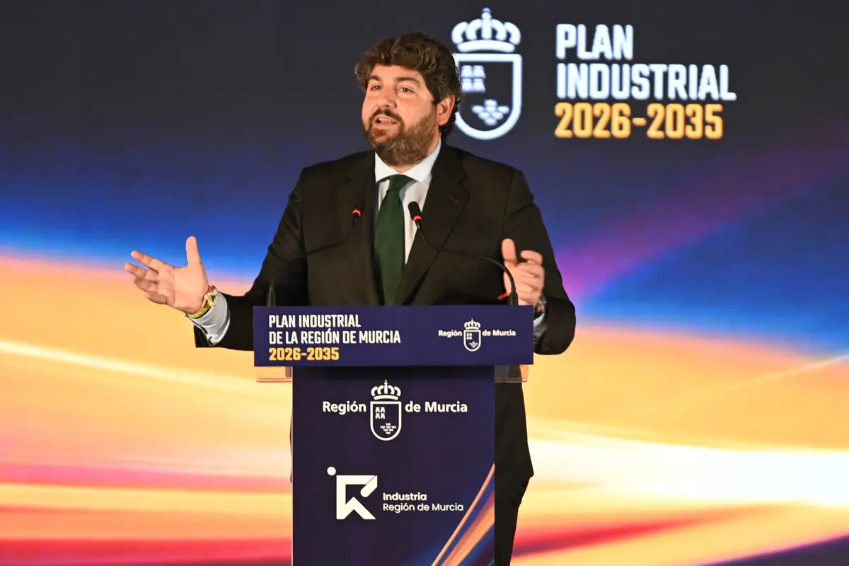 Hombre con traje hablando en un atril durante la presentación del Plan Industrial de la Región de Murcia 2026-2035 sobre un fondo con colores degradados