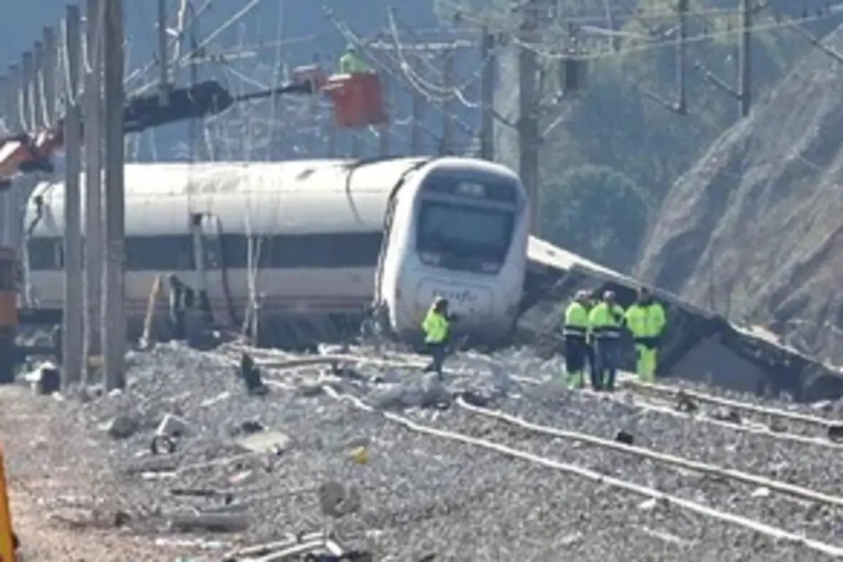 Tren descarrilado en una vía ferroviaria con escombros en las vías y personal de emergencia trabajando en la zona Tren descarrilado en una vía ferroviaria con escombros en las vías y personal de emergencia trabajando en la zona