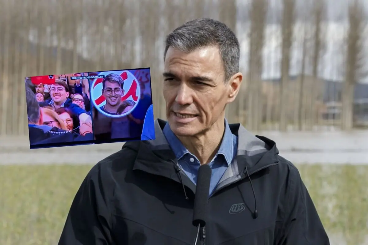 Hombre de mediana edad con chaqueta oscura hablando ante un micrófono al aire libre mientras sobre su imagen aparece superpuesta una pantalla con una escena de jóvenes sonriendo en un evento multitudinario