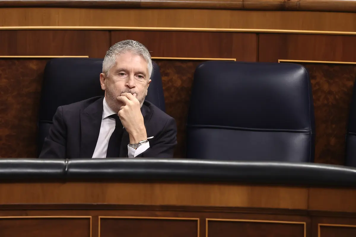 Hombre de traje oscuro sentado pensativo en un escaño vacío de un parlamento