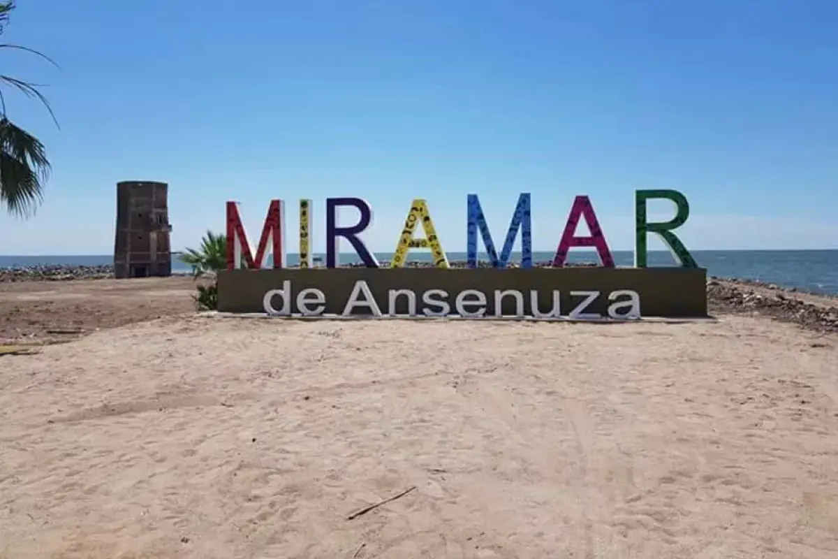 Cartel colorido de Miramar de Ansenuza frente a la playa y el mar en un día soleado