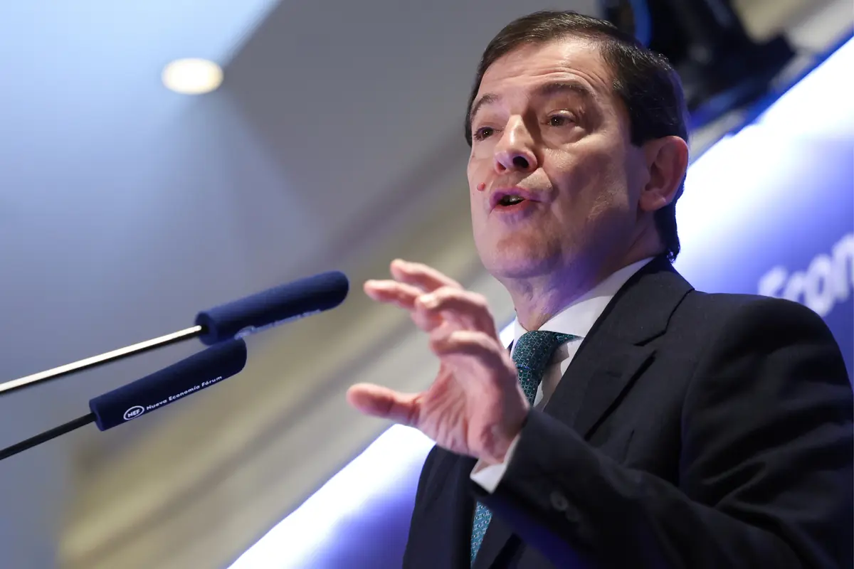 Hombre con traje y corbata hablando en un podio frente a un micrófono durante una conferencia