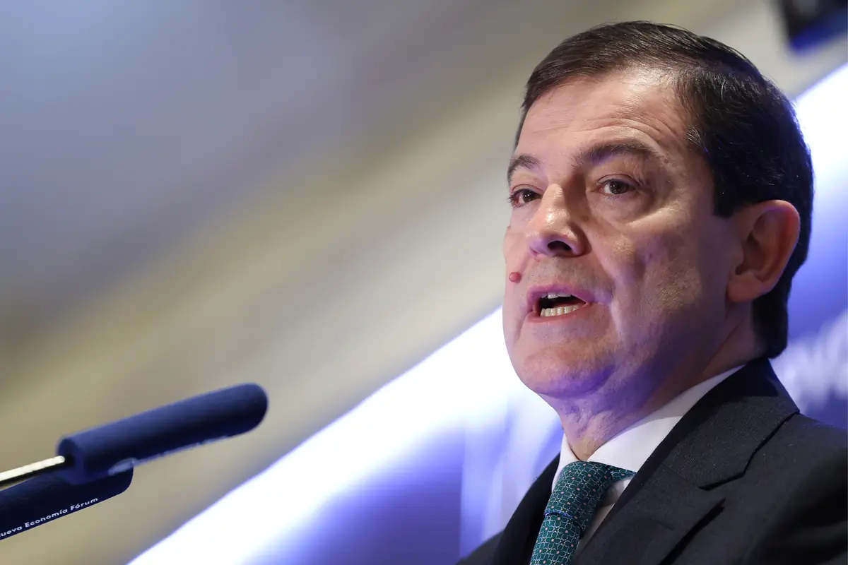 Hombre de mediana edad con traje y corbata hablando frente a un micrófono en un acto público