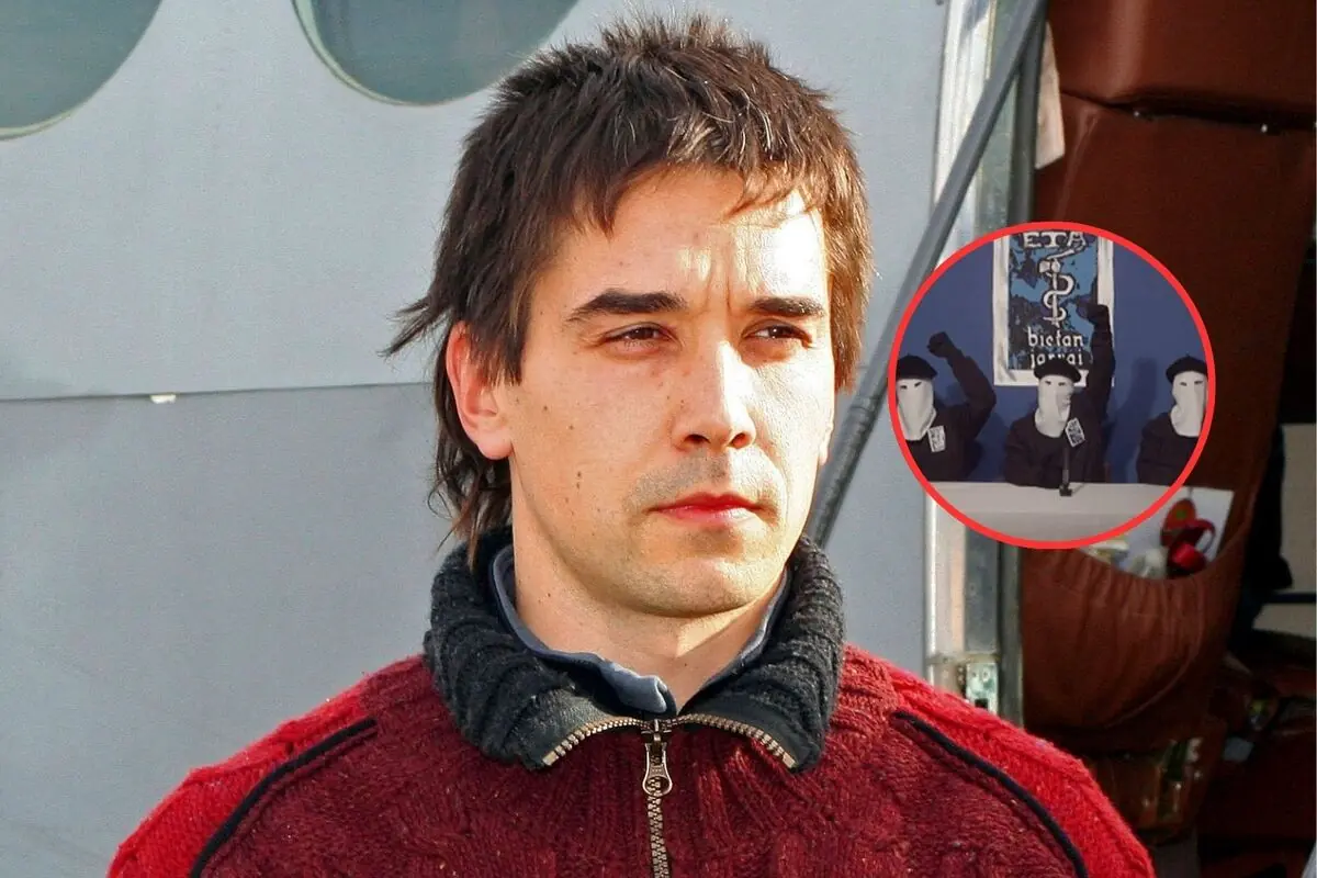 Hombre joven con jersey rojo mira serio a la cámara con un círculo que muestra a tres personas encapuchadas levantando el puño frente a un cartel en una pared azul