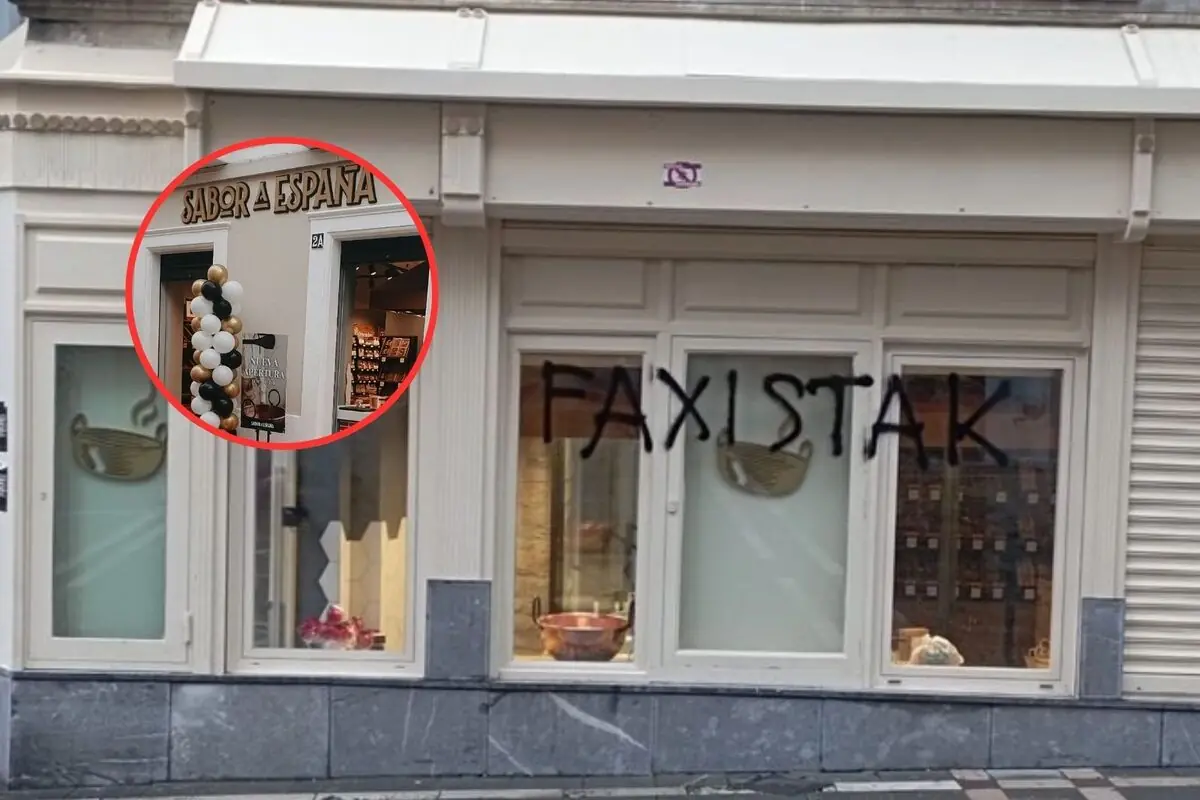 Fachada de una tienda con escaparates blancos y la palabra faxistak pintada con espray negro y un recuadro que muestra el rótulo sabor a España en la entrada del local