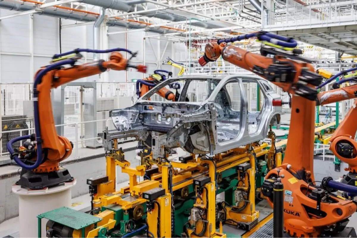 Línea de producción automatizada con brazos robóticos ensamblando la carrocería de un automóvil en una fábrica moderna