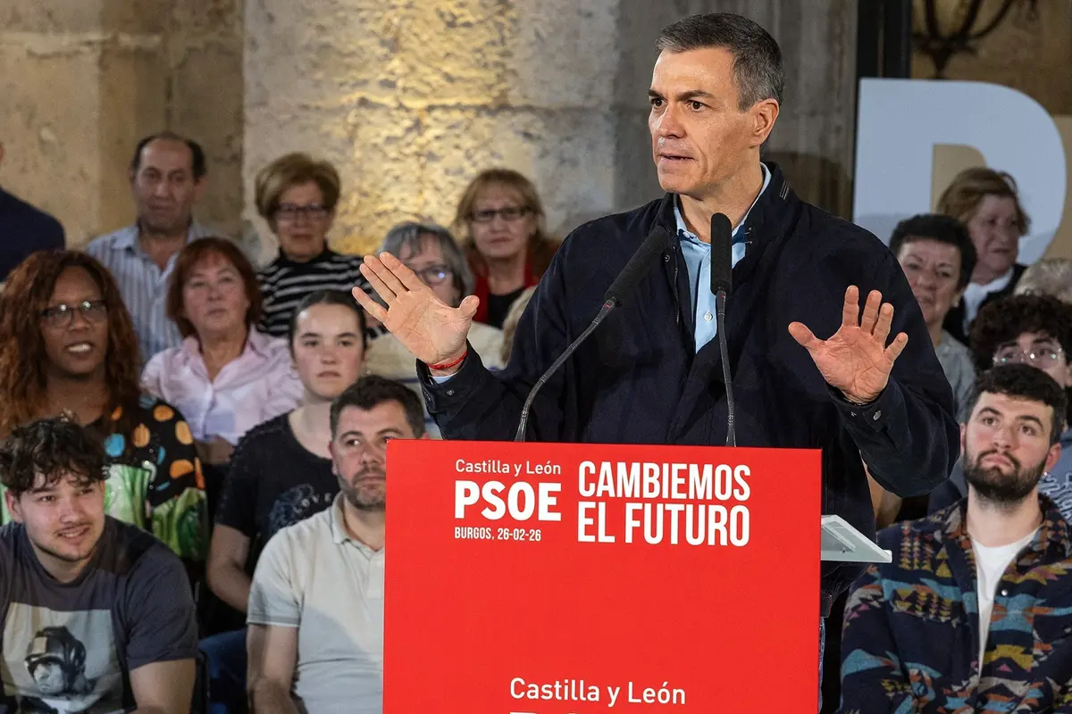 Hombre hablando en un mitin político del PSOE en Castilla y León frente a un atril rojo con el lema Cambiemos el futuro rodeado de público atento