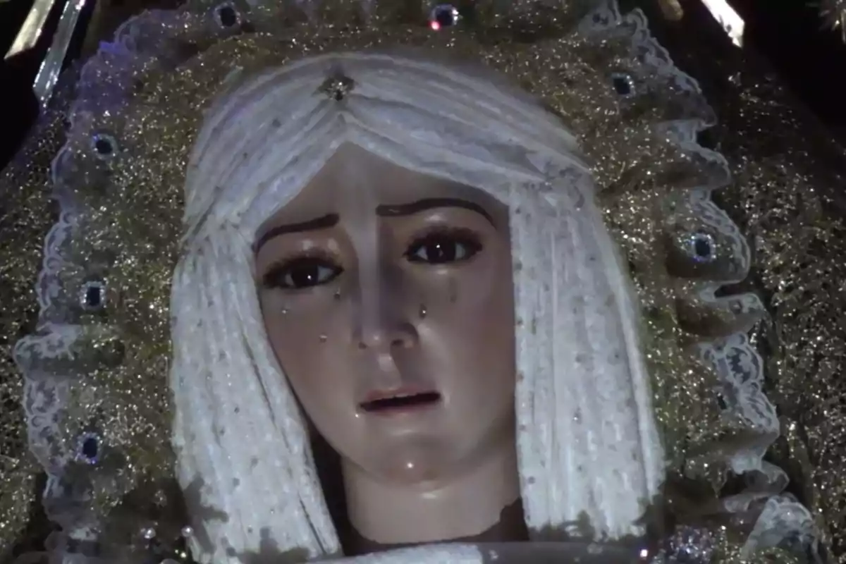 Una estatua religiosa con un manto dorado y lágrimas en el rostro. Una estatua religiosa con un manto dorado y lágrimas en el rostro.