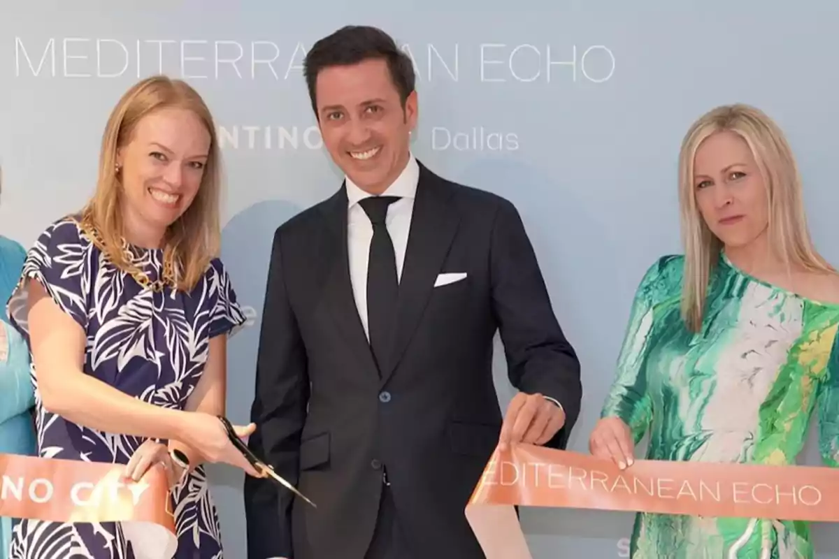 Tres personas sonríen mientras cortan una cinta en un evento de inauguración. Tres personas sonríen mientras cortan una cinta en un evento de inauguración.